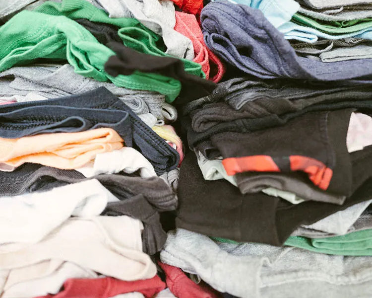 Diverse pile of Faded Vibes t-shirts, showing the unique, one-of-a-kind nature of our curated vintage collection.
