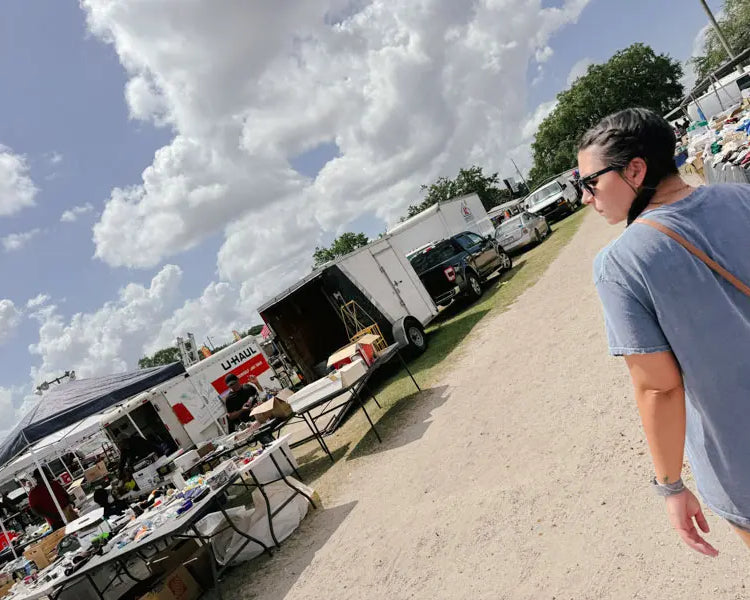 Faded Vibes team member sourcing unique vintage t-shirts at an outdoor market, showing our sustainable second-hand model.