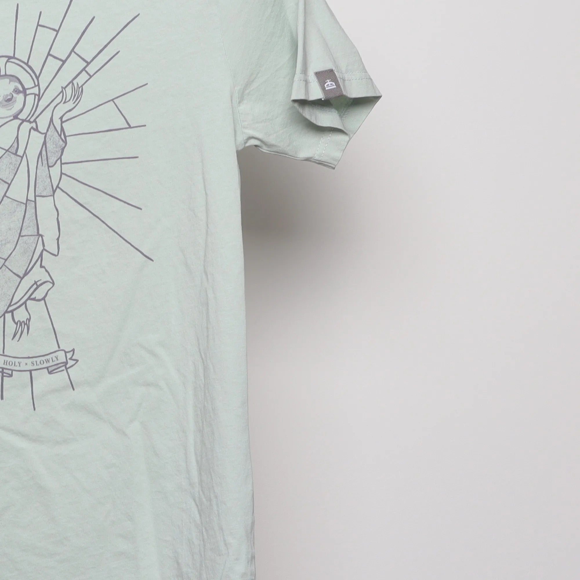 Close-up of the sleeve on the Modern Sloth Saint Parody Graphic T-Shirt XS