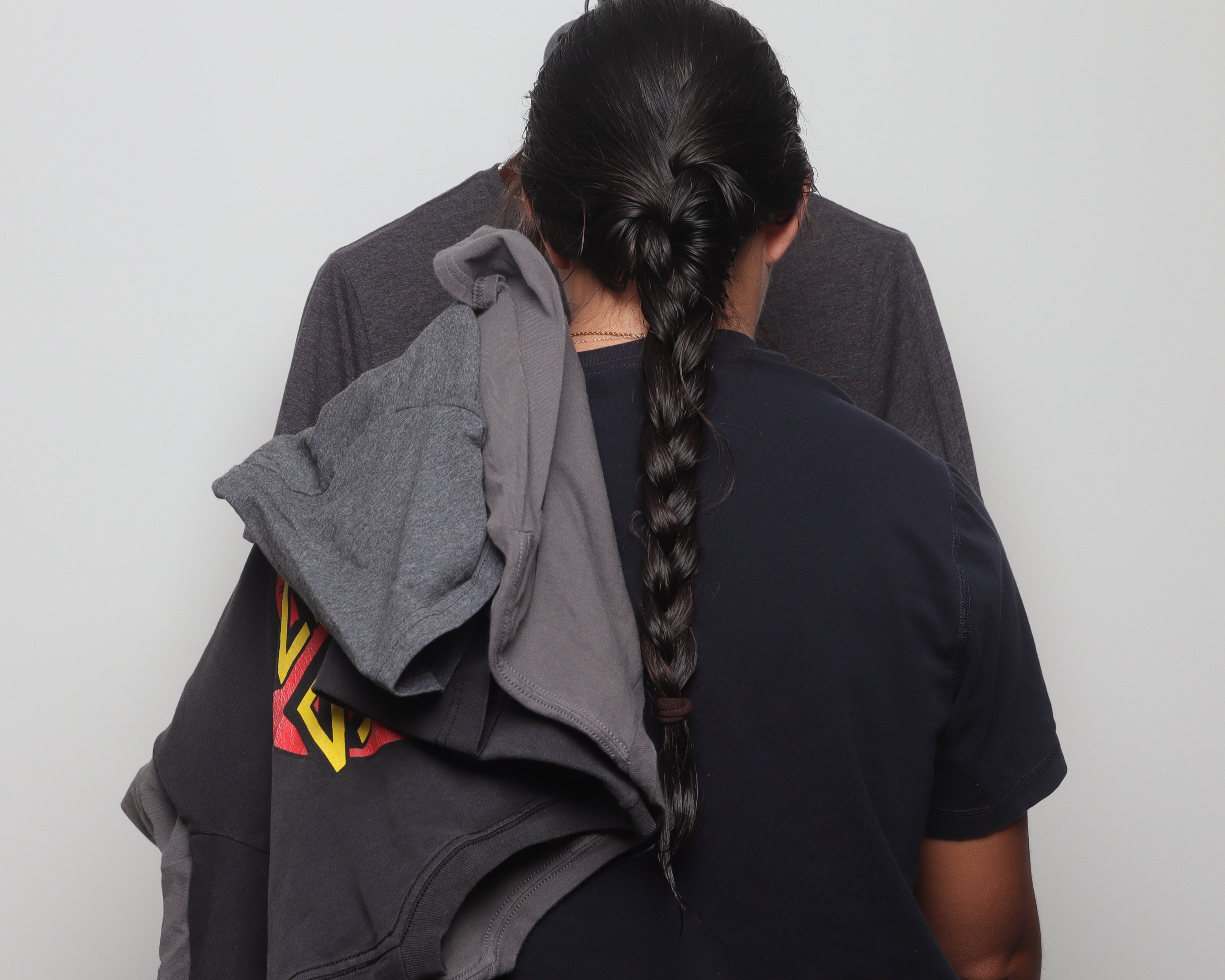 A Faded Vibes curator meticulously hanging and organizing unique vintage t-shirts, showcasing the expert curation process for our one-of-a-kind collection.