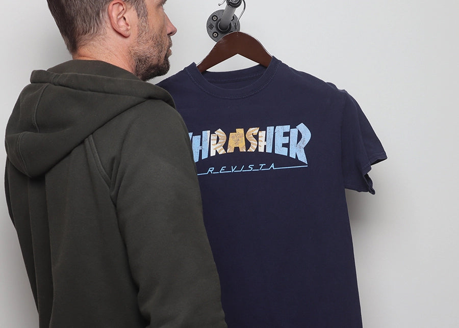 Faded Vibes founder Doug inspects a vintage Thrasher t-shirt, showing our hands-on expert curation and quality check.