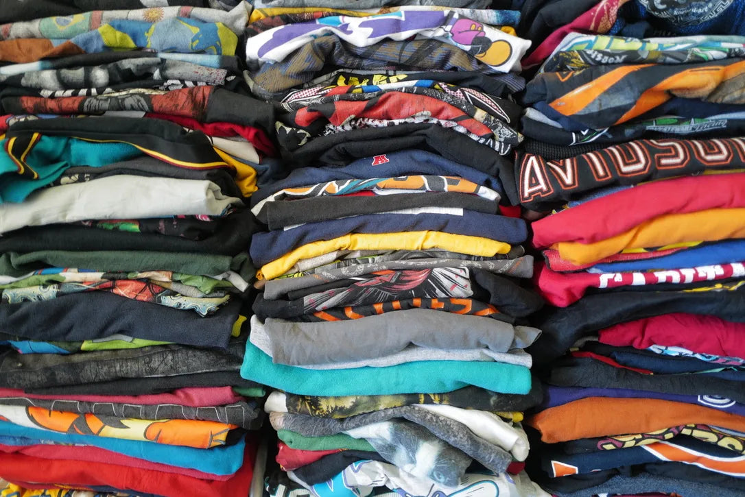 Behind-the-scenes: massive, colorful stacks of folded vintage t-shirts showing our large one-of-a-kind inventory.