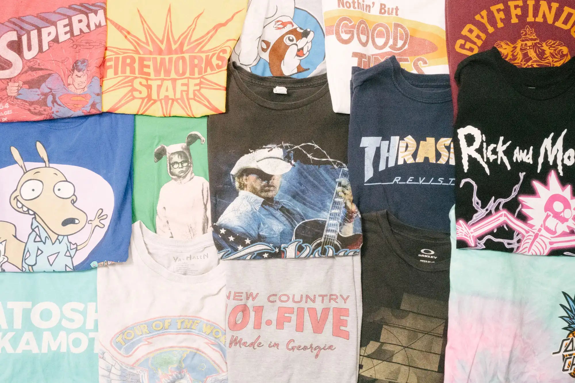 Flat lay of diverse Faded Vibes vintage t-shirts. Unique graphics, band tees, and one-of-a-kind sustainable fashion.