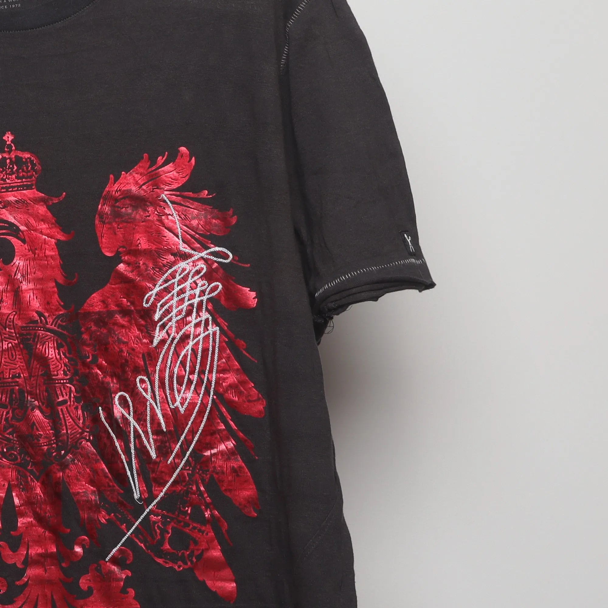 Close-up of the sleeve on the Vintage 2000s Marc Ecko Foil Eagle T-Shirt XL