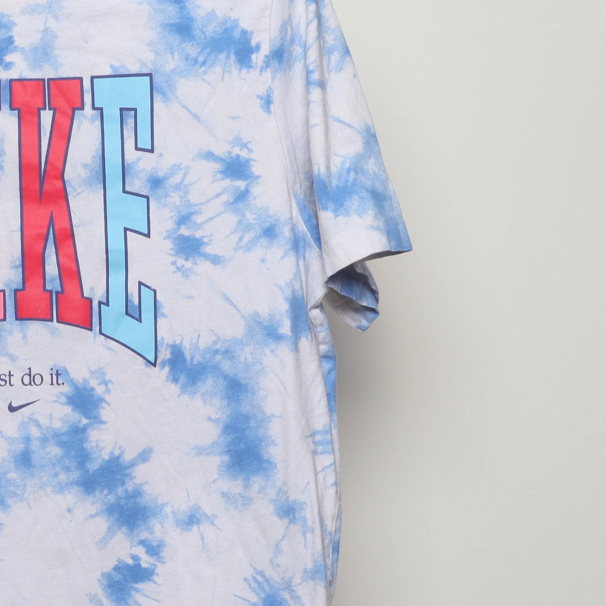 Close-up of the sleeve on the Vintage 2010s Nike Tie-Dye Peace Graphic Tee XL