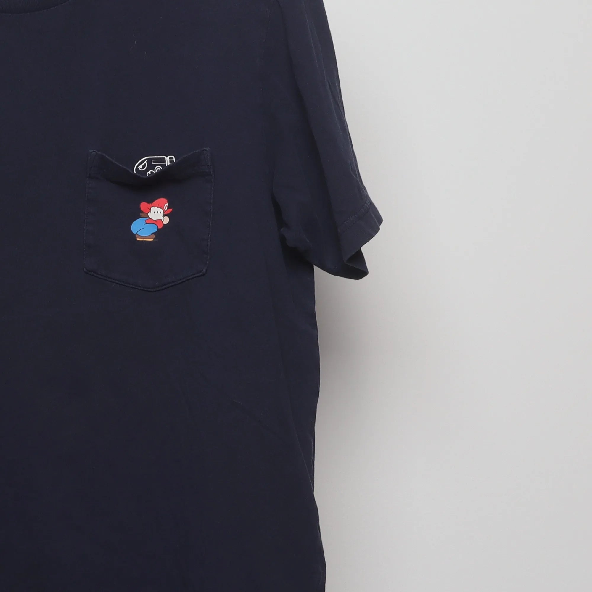 Close-up of the sleeve on the Vintage 2010s Uniqlo Nintendo Mario Pocket T-Shirt L