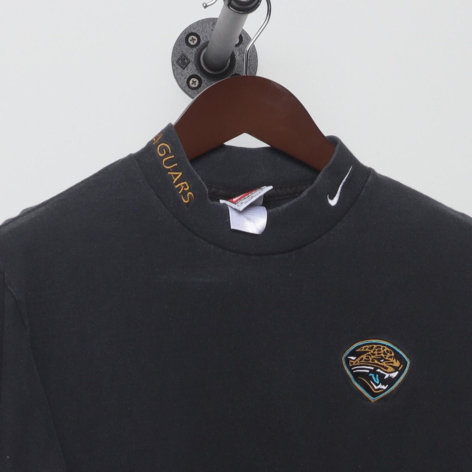 Close-up of the collar and tag on the Vintage 1990s Nike "Jacksonville Jaguars Mock Neck" T-Shirt - M