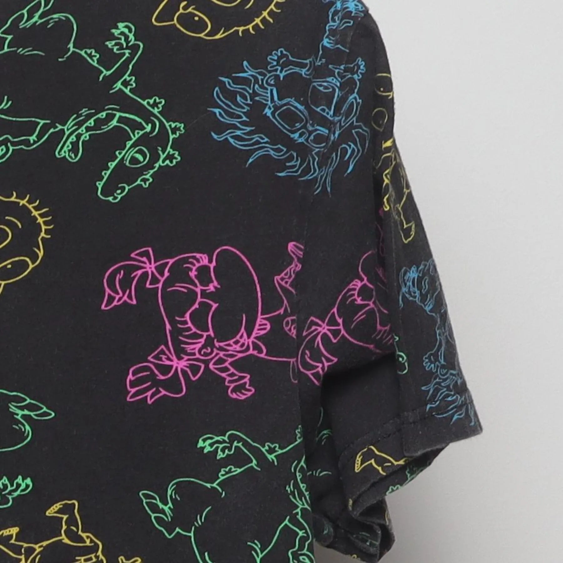 Close-up of the Right sleeve on the Vintage Y2K Nickelodeon "Rugrats Neon AOP" T-Shirt - M