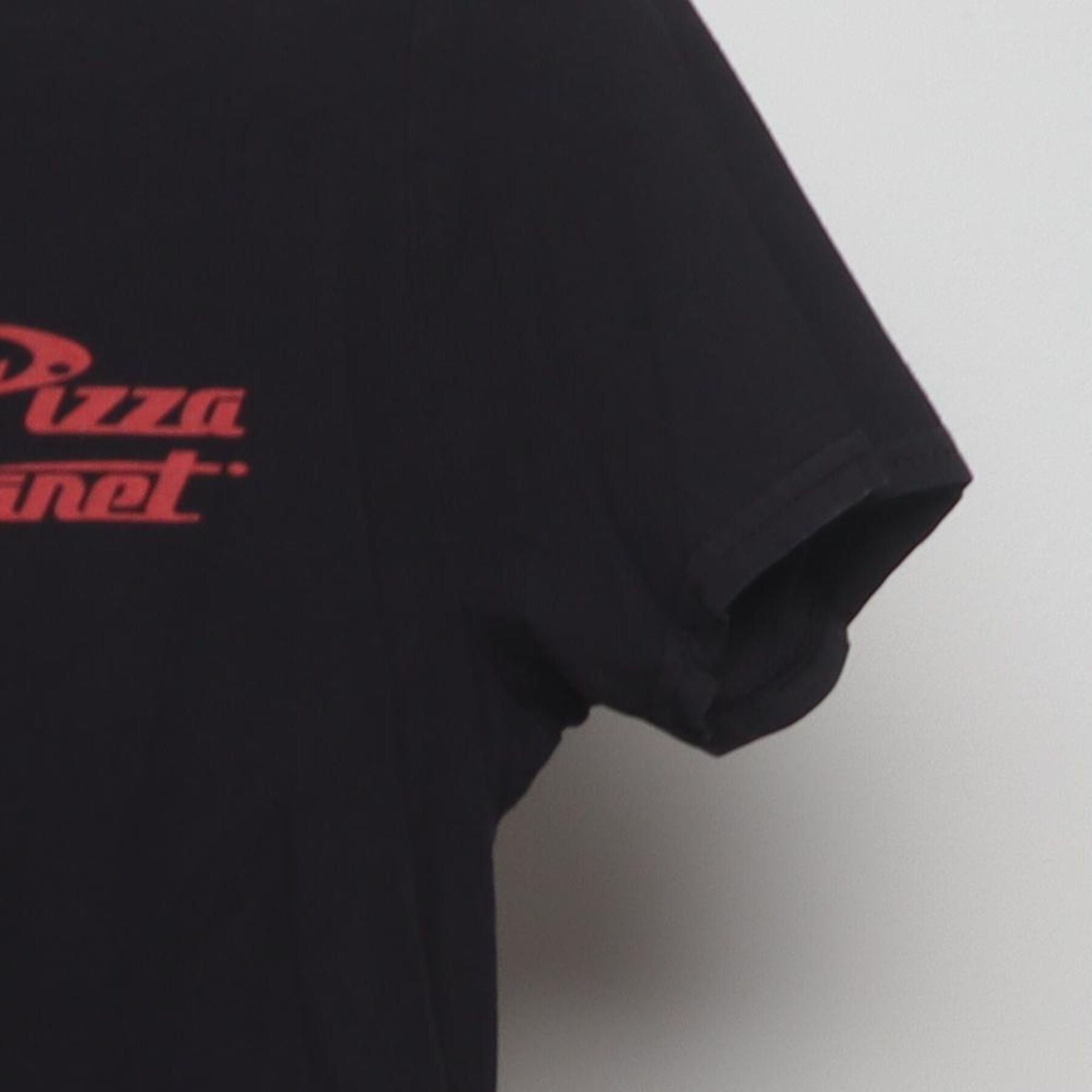 Close-up of the Right sleeve on the Vintage Y2K Disney / Pixar "Pizza Planet The Claw" T-Shirt - S